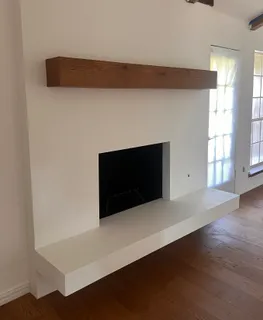 an empty room with wooden floor and fireplace