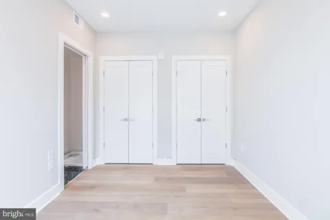 a view of an empty room with closet and entryway