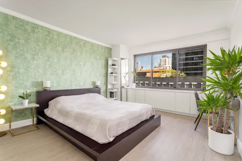 a bedroom with a bed and a potted plant