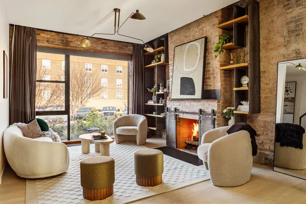 a living room with furniture a fireplace and a large window