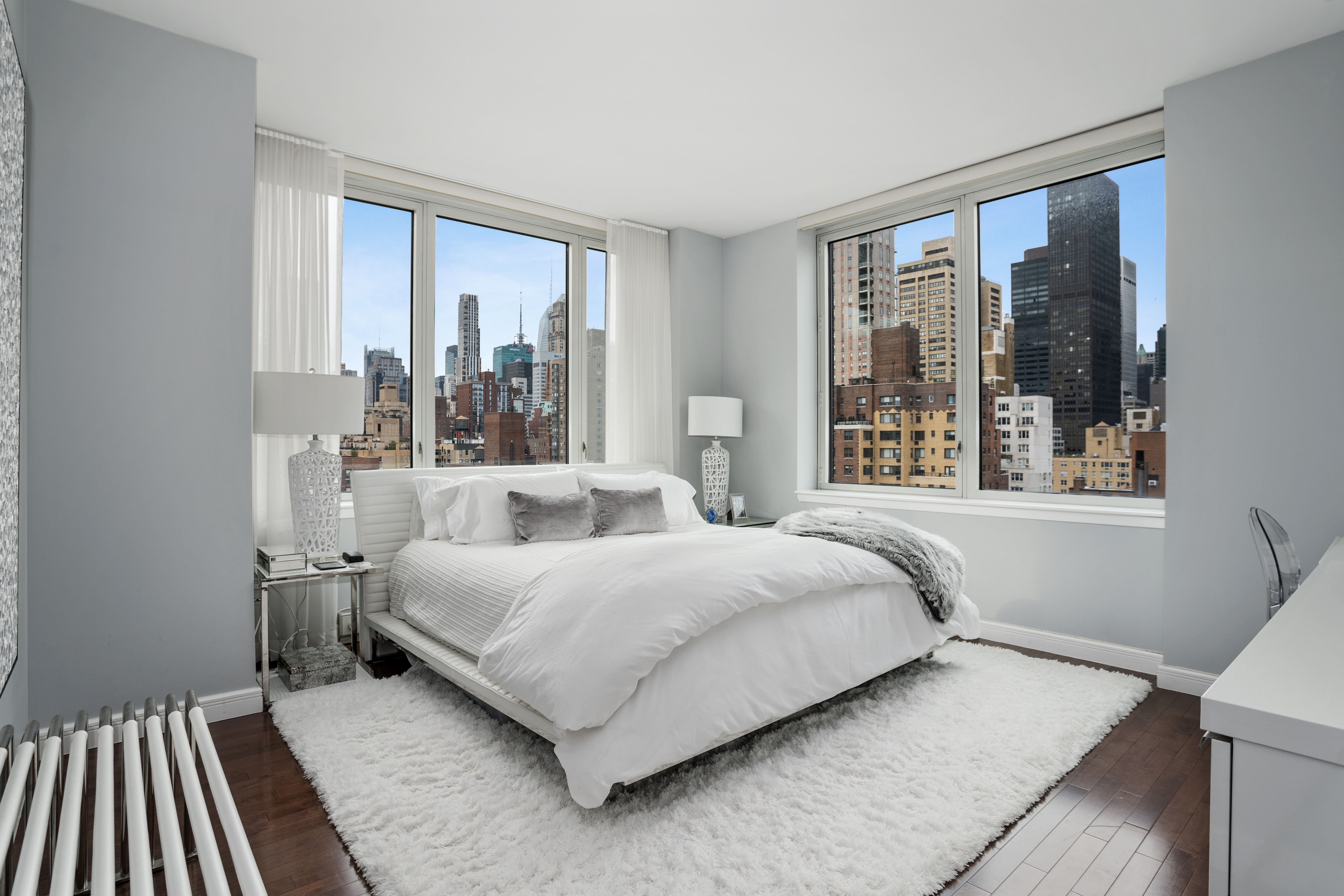 225 East 34th Street, Unit 17C Manhattan, NY 10016 - Photo 3 of 19 a bedroom with a bed lamp and a large window