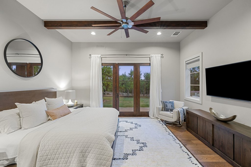 2560 Bell Springs Road Dripping Springs, TX 78620 - Photo 31 of 42 a bedroom with a large bed and a flat screen tv