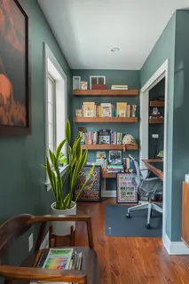 a living room with furniture and a book shelf