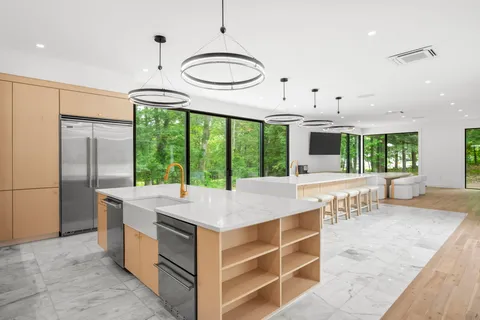 a kitchen with kitchen island a large counter top space a sink stainless steel appliances and cabinets