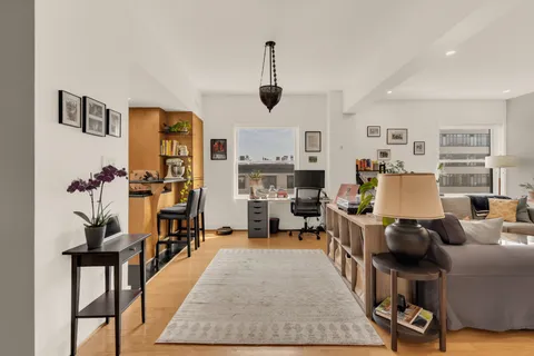 a living room with furniture a flat screen tv and a table