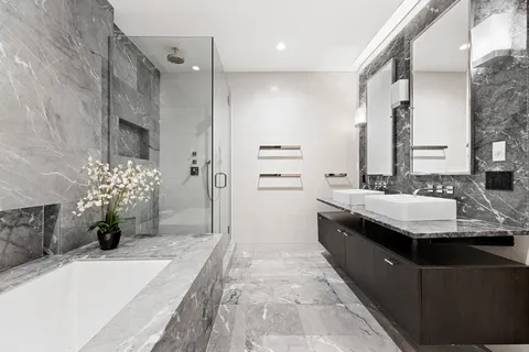 a bathroom with a granite countertop sink a mirror and a bathtub