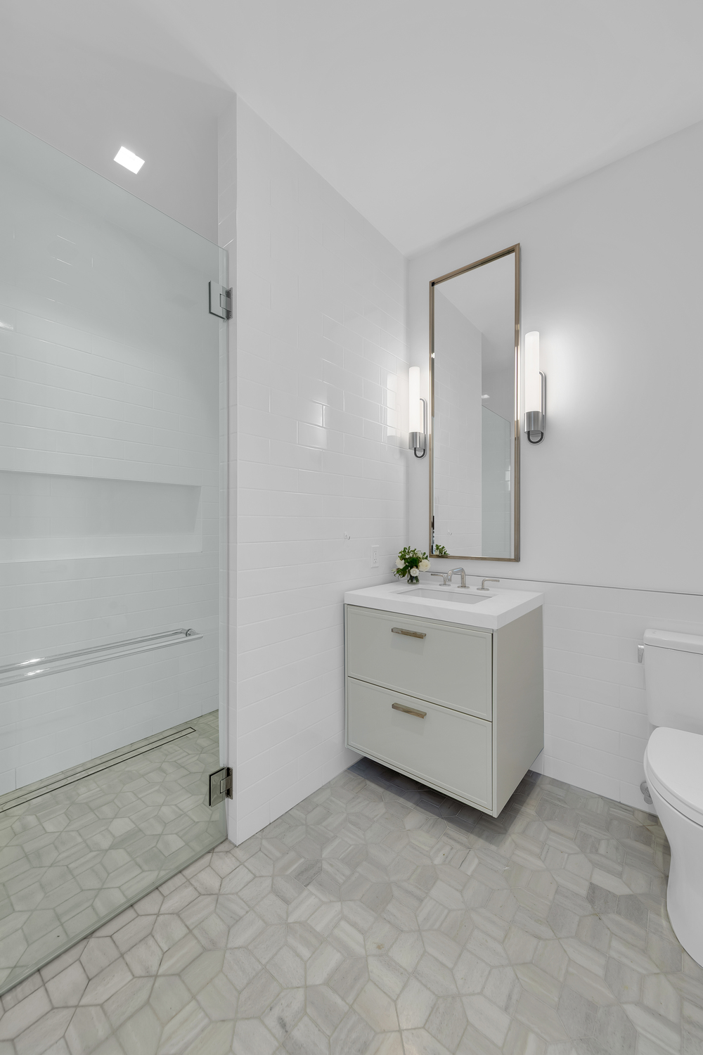 200 East 83rd Street, Unit 29B Manhattan, NY 10028 - Photo 8 of 20 a bathroom with a sink a toilet and a mirror