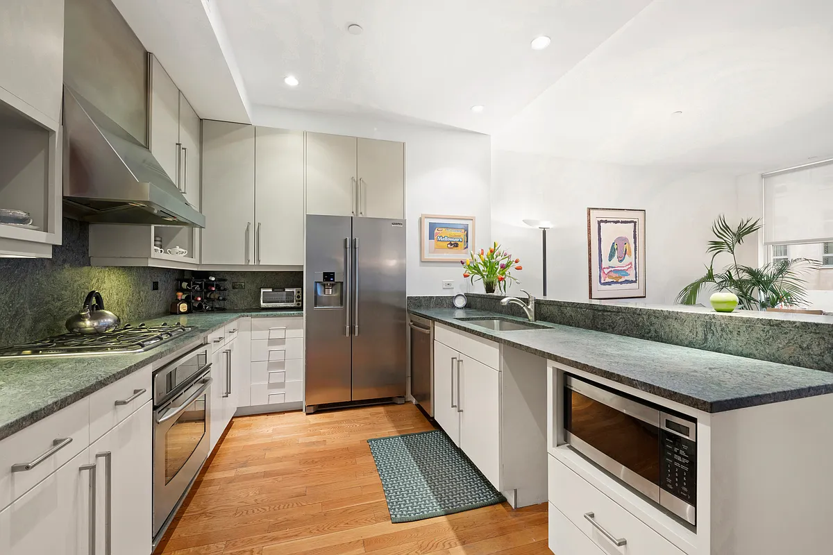 102 Fulton Street, Unit 2E Manhattan, NY 10038 - Photo 2 of 7 a large kitchen with stainless steel appliances granite countertop a stove a sink and a refrigerator