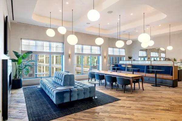 a large kitchen with a large island oven a dining table and chairs with wooden floor