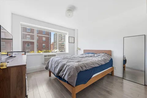 a bedroom with a bed and a large window