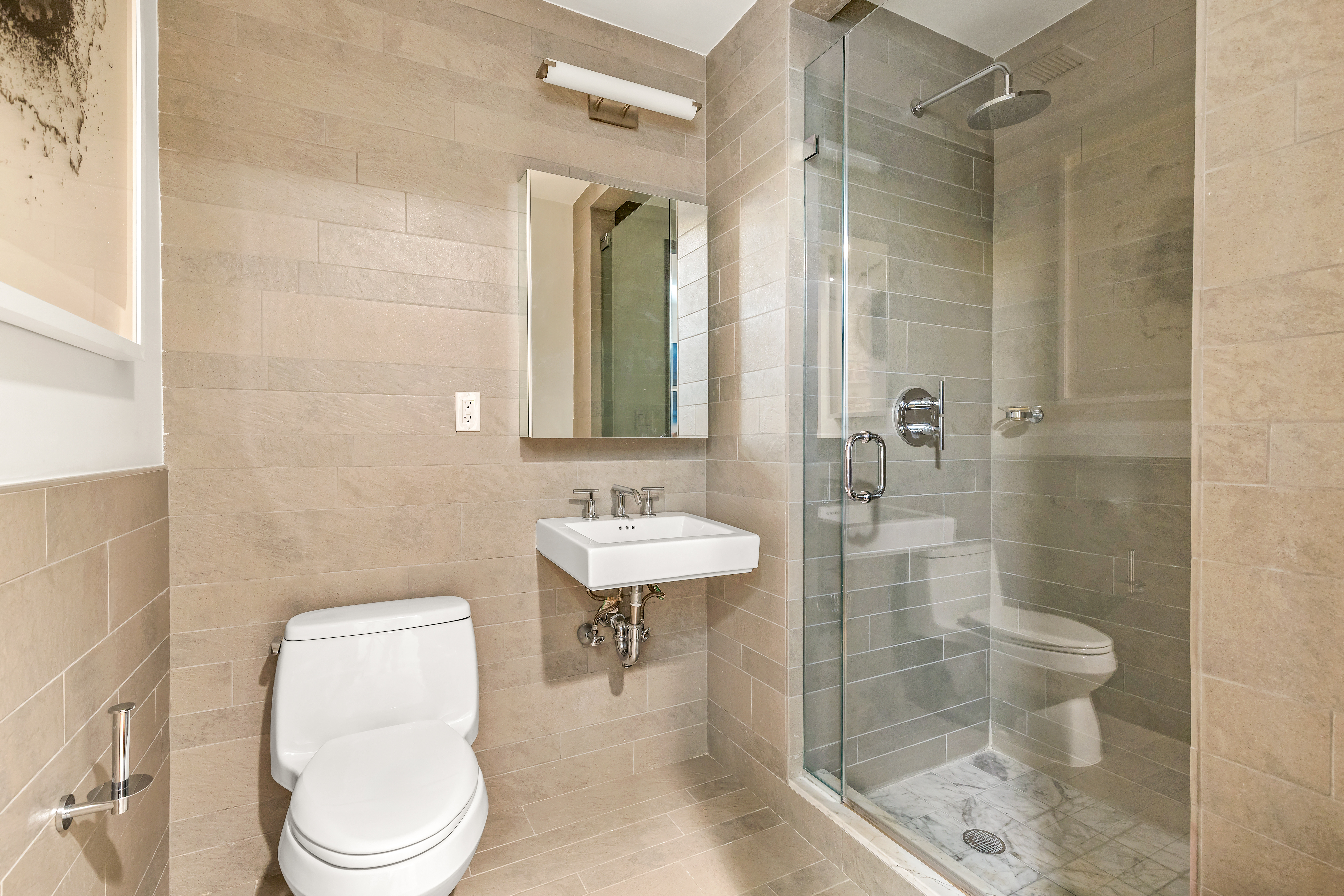454 West 54th Street, Unit 5G Manhattan, NY 10019 - Photo 8 of 17 a bathroom with a toilet a sink and shower