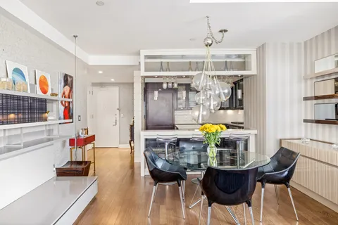 a living room with stainless steel appliances furniture and a chandelier