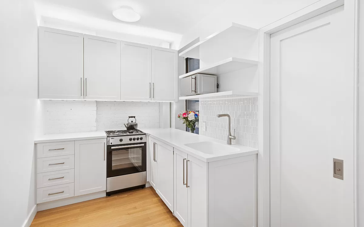 305 East 91st Street, Unit 2C Manhattan, NY 10128 - Photo 2 of 6 a kitchen with white cabinets and white appliances
