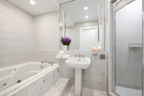 a bathroom with a bathtub sink and mirror
