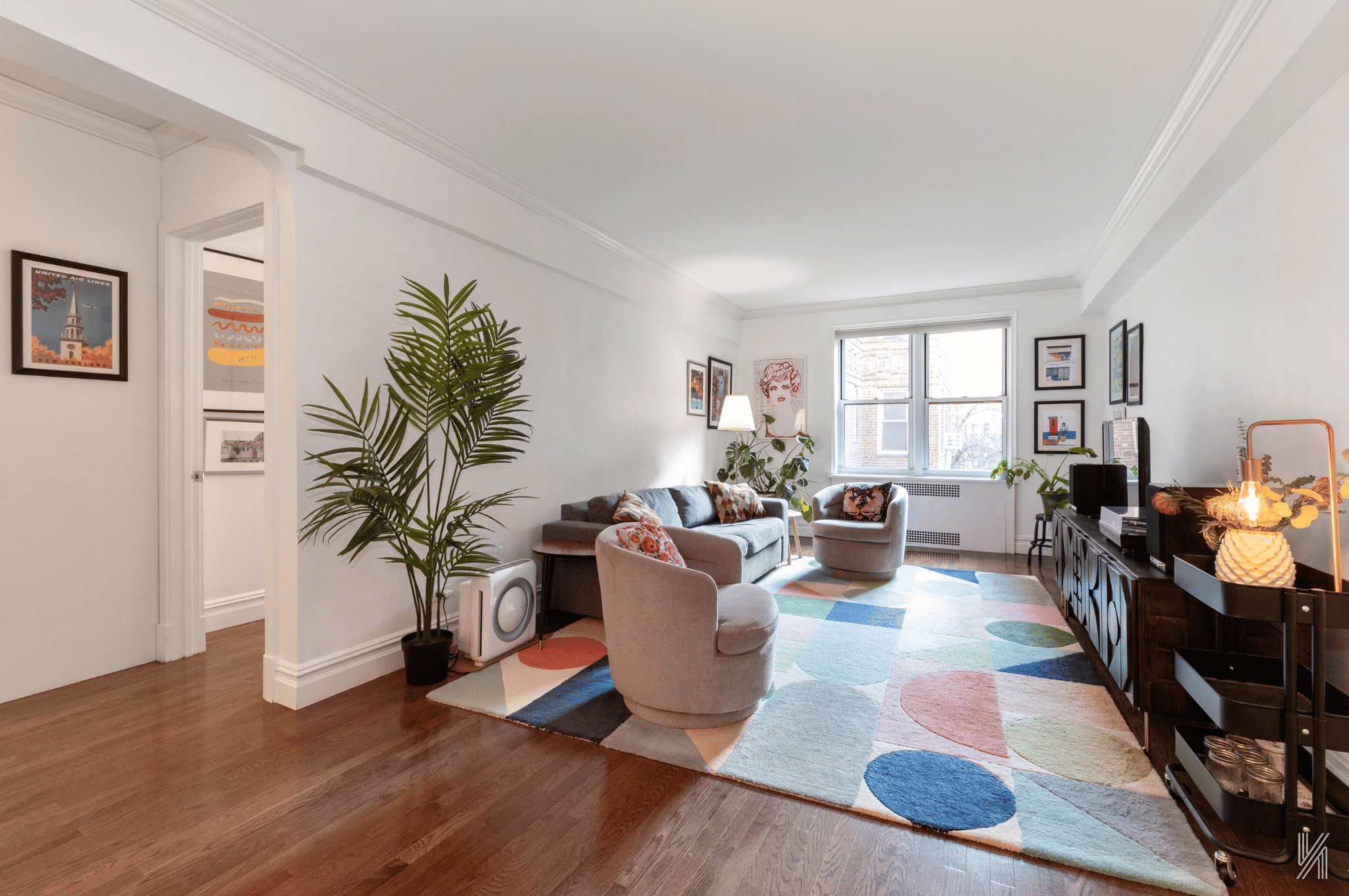73-12 35th Avenue, Unit E23 Queens, NY 11372 - Photo 2 of 16 a living room with fireplace furniture and a potted plant