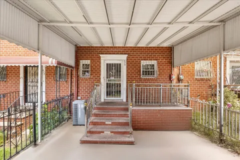 a view of a porch with a floor to ceiling window and stairs