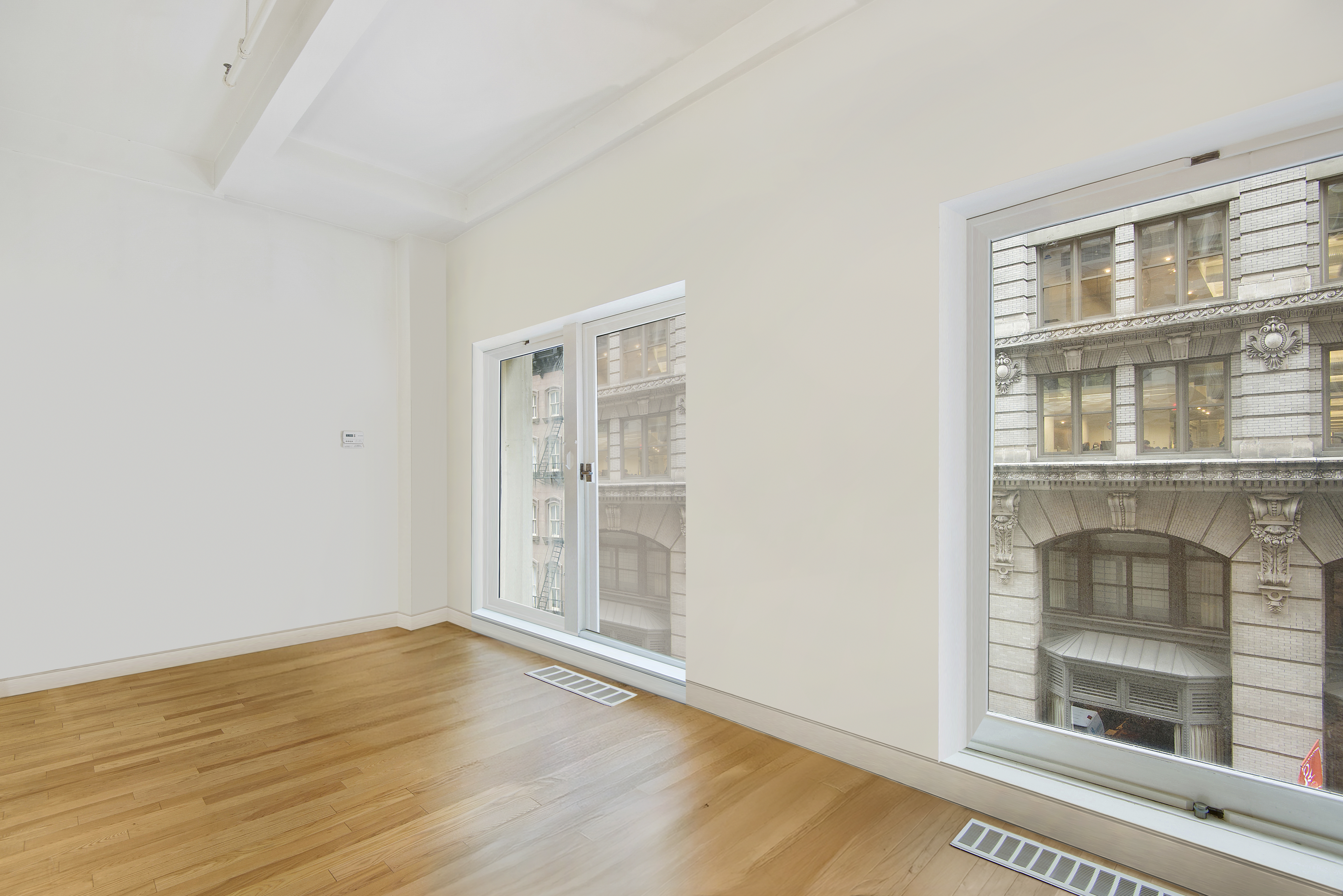 16 West 19th Street, Unit 3A Manhattan, NY 10011 - Photo 7 of 8 a view of an empty room with wooden floor and a window