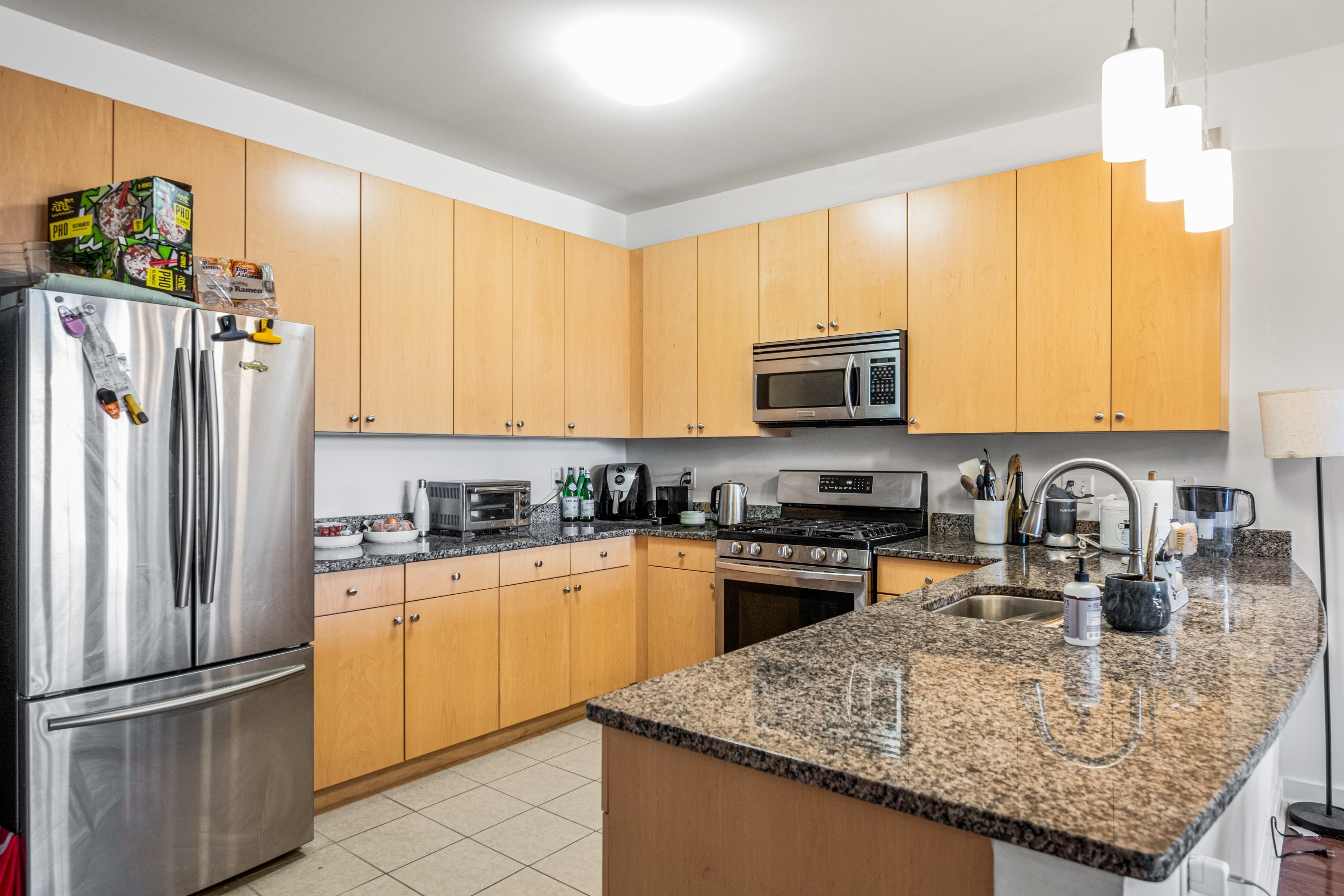 3201 St Paul Street, Unit 310 Baltimore, MD 21218 - Photo 16 of 20 a kitchen with granite countertop a refrigerator stove and sink