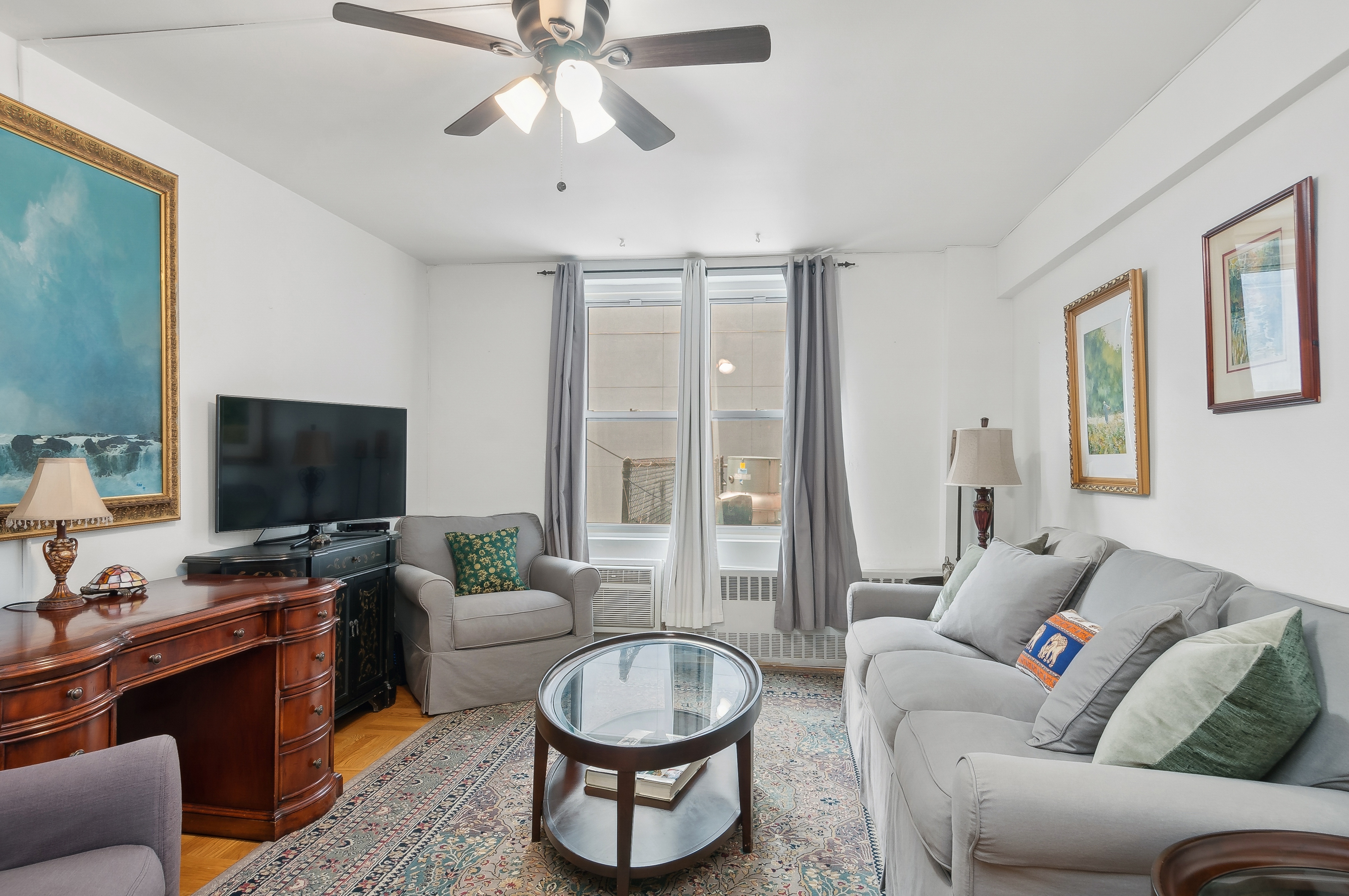 408 West 34th Street, Unit 1F Manhattan, NY 10001 - Photo 3 of 13 a living room with furniture and a flat screen tv