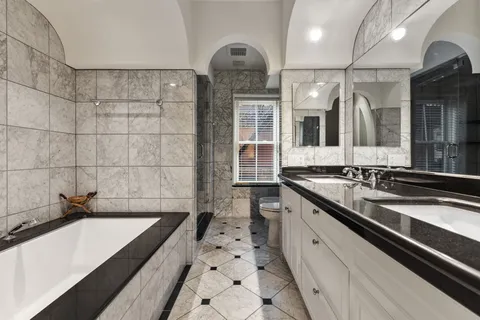 a large white kitchen with a sink and large stainless steel appliances