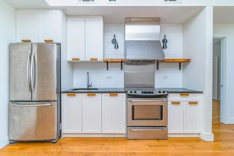 a kitchen with stainless steel appliances granite countertop a refrigerator a stove and a sink