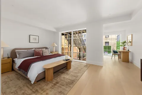 a spacious bedroom with a large bed and a wooden floor