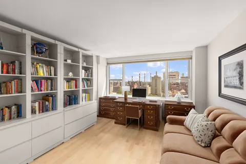 a living room with furniture and a book shelf