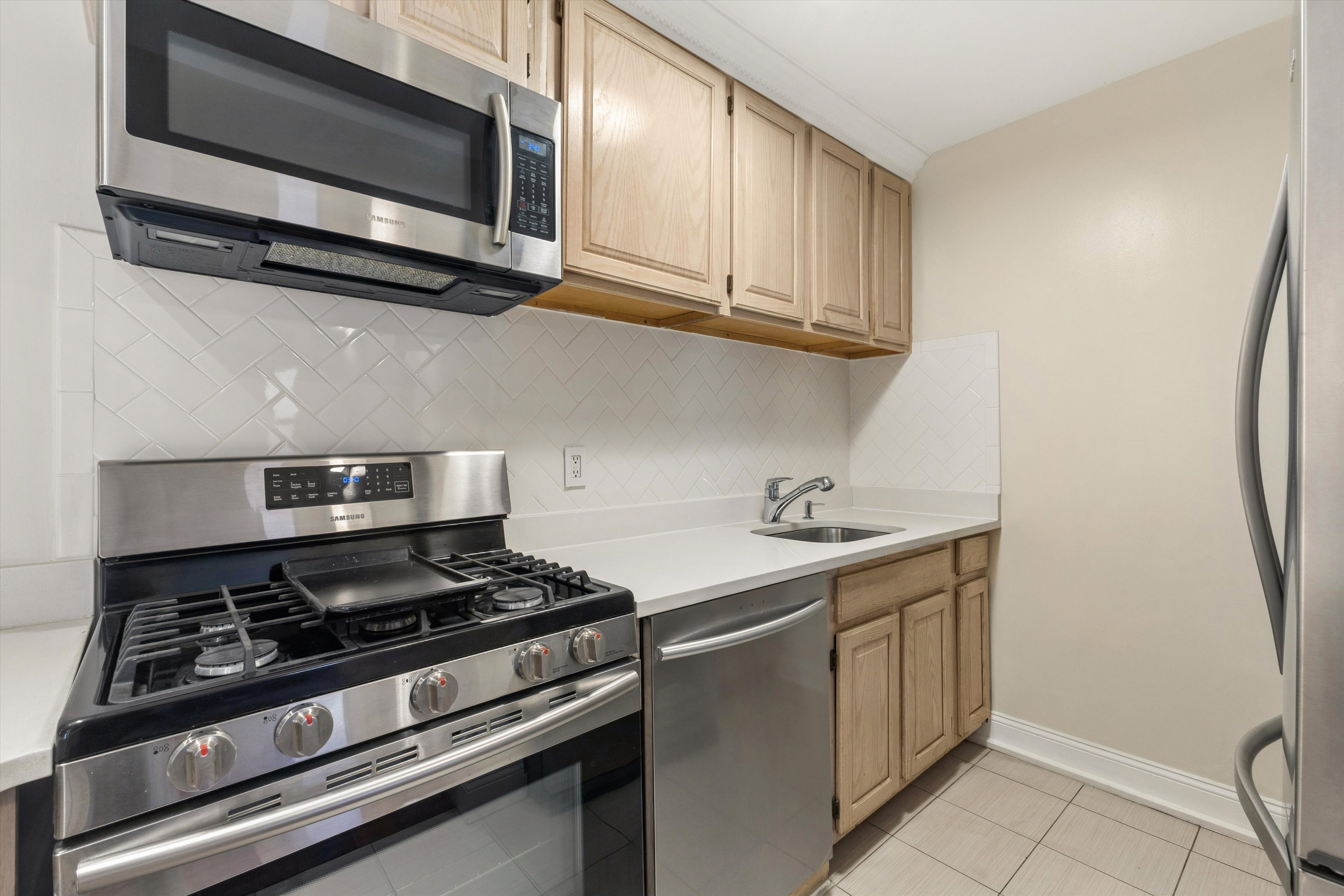 1919 Madison Avenue, Unit 418 Manhattan, NY 10035 - Photo 6 of 16 a kitchen with stainless steel appliances a sink stove and microwave