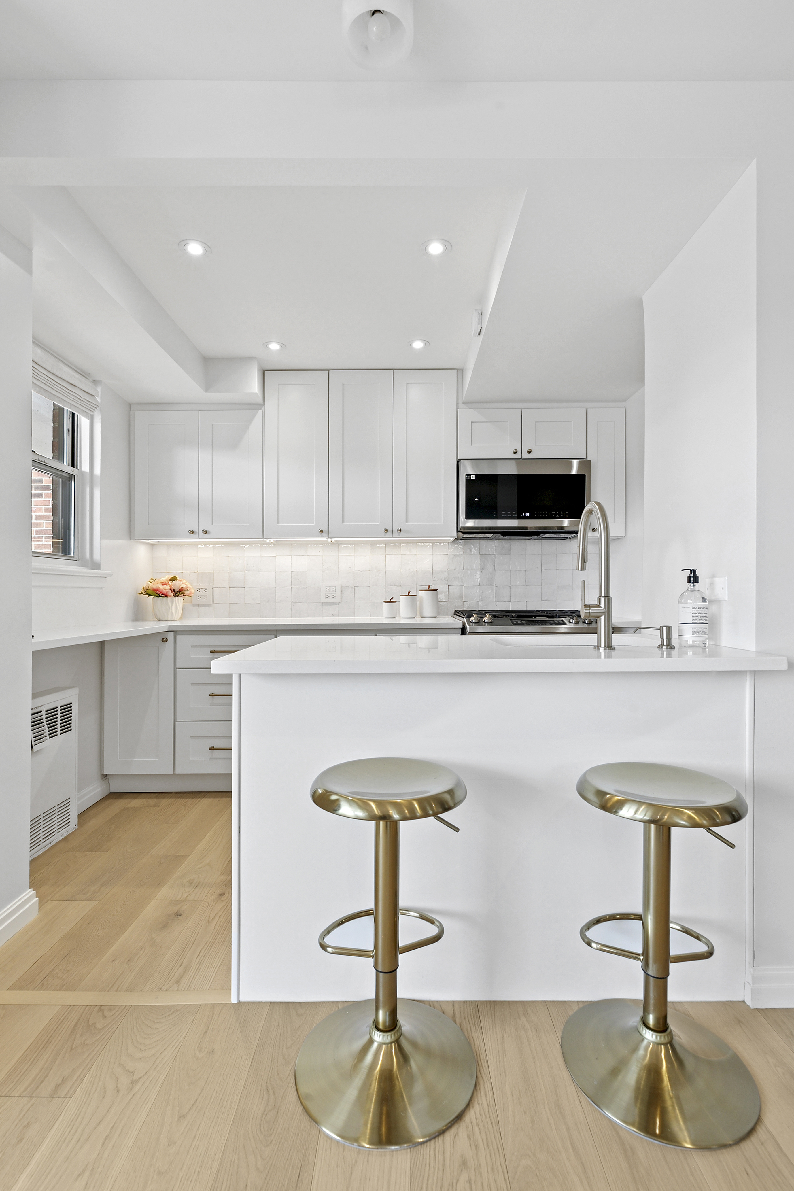 300 East 71st Street, Unit 17DEF Manhattan, NY 10021 - Photo 4 of 16 a kitchen with kitchen island granite countertop a counter space a sink appliances and cabinets