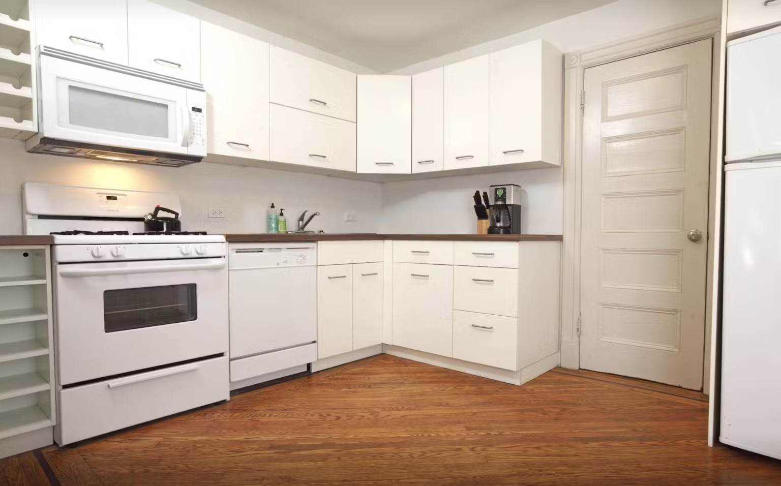 a kitchen with white cabinets stainless steel appliances and sink