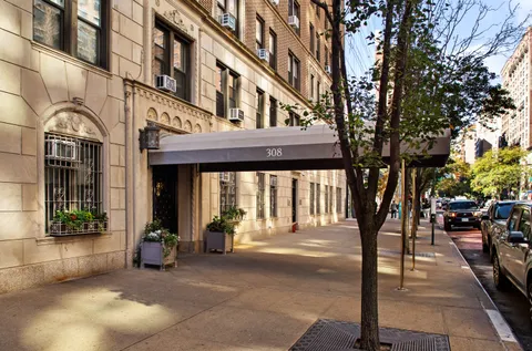 a front view of a building and car parked