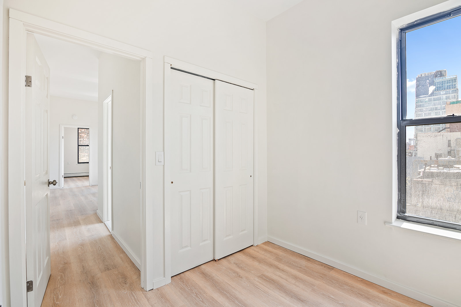 108 Stanton Street, Unit 5D Manhattan, NY 10002 - Photo 6 of 6 a view of a hallway with wooden floor and a bathroom