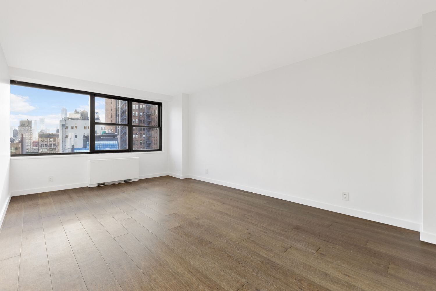 7 East 14th Street, Unit 17RS Manhattan, NY 10003 - Photo 3 of 9 an empty room with wooden floor and windows