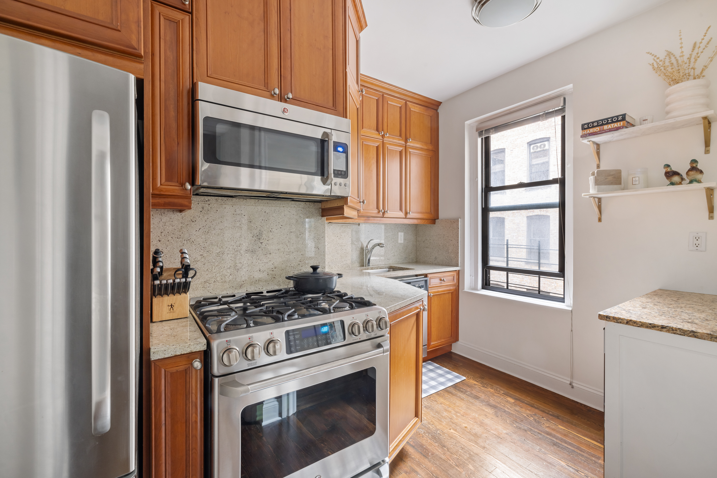 305 East 88th Street, Unit 4A Manhattan, NY 10128 - Photo 8 of 13 a kitchen with a stove microwave and refrigerator