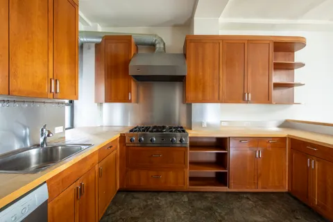 a kitchen with stainless steel appliances granite countertop a sink stove and cabinets