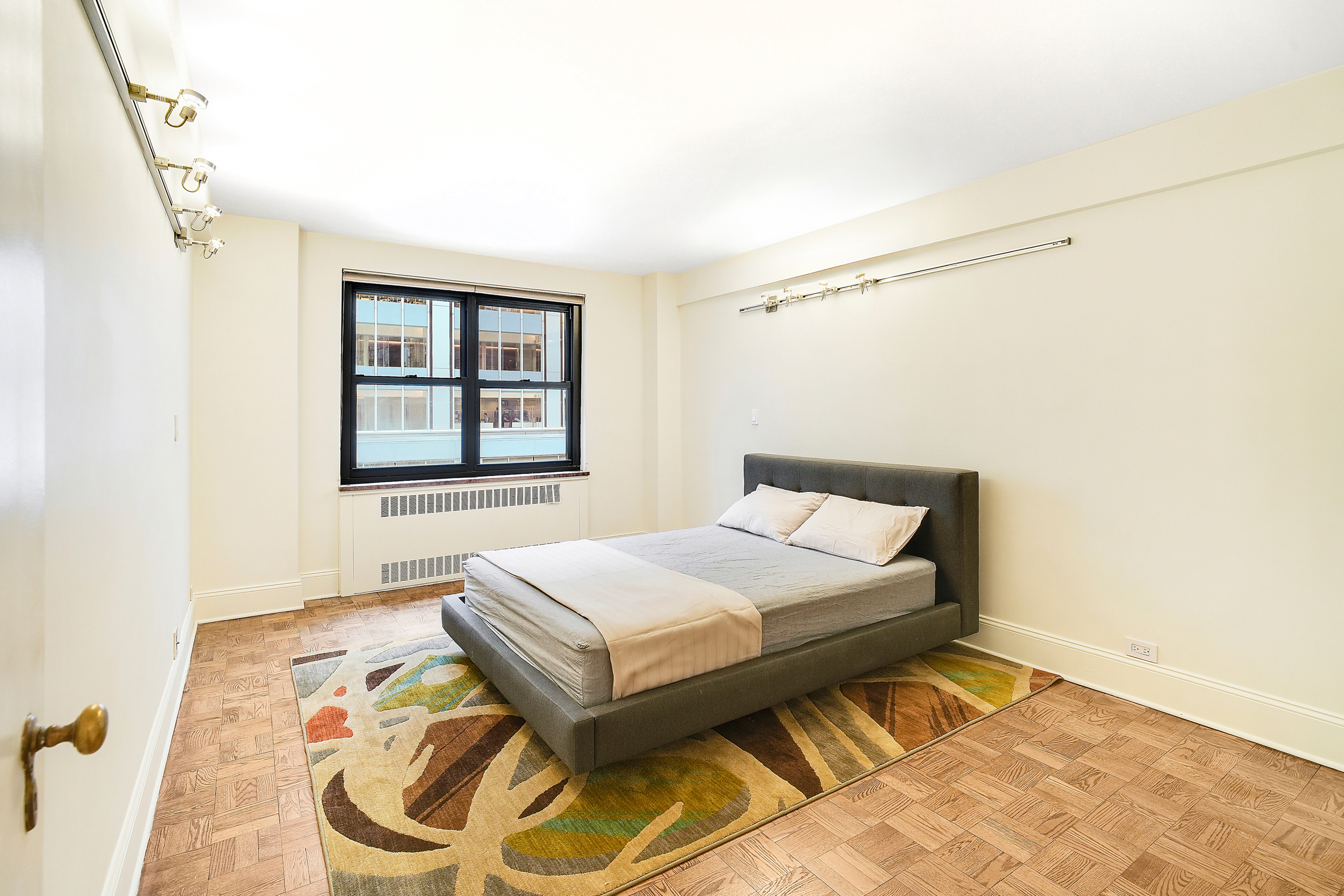 135 East 54th Street, Unit 12M Manhattan, NY 10022 - Photo 4 of 10 a bedroom with a bed and a window