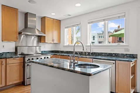 a kitchen with granite countertop a sink stove and cabinets