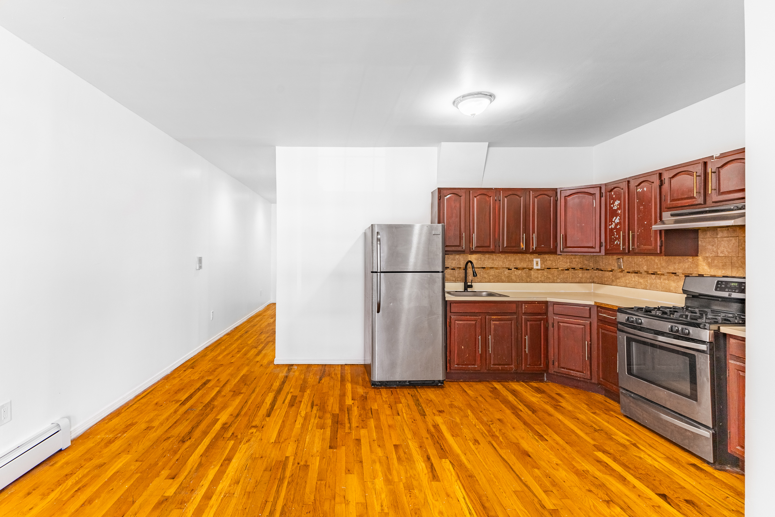 434 Lexington Avenue Brooklyn, NY 11221 - Photo 3 of 22 a kitchen with wooden floors and wooden cabinets