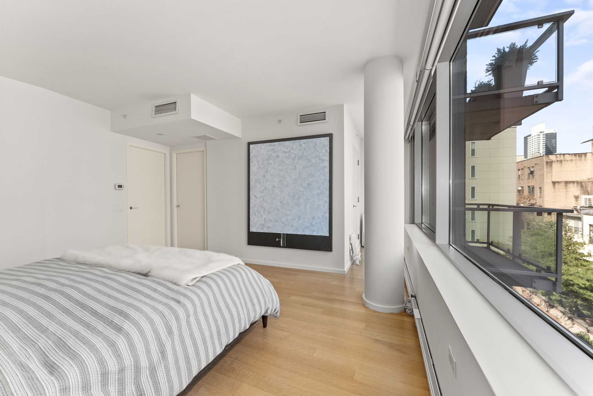 425 West 53rd Street, Unit 416 Manhattan, NY 10019 - Photo 8 of 19 a bedroom with a bed and glass door