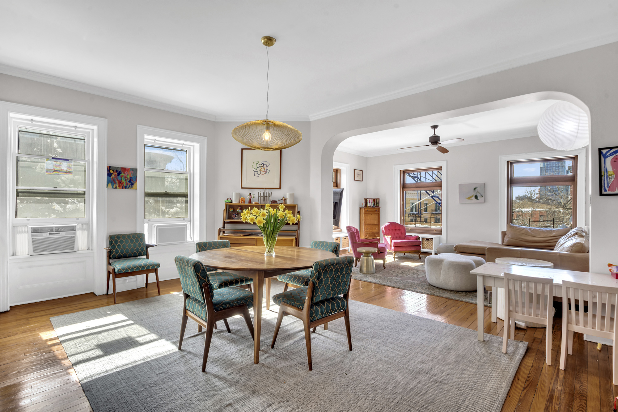 275 Clinton Avenue, Unit 4-1 Brooklyn, NY 11205 - Photo 4 of 20 a view of a dining room and livingroom with furniture wooden floor a rug a painting and a chandelier