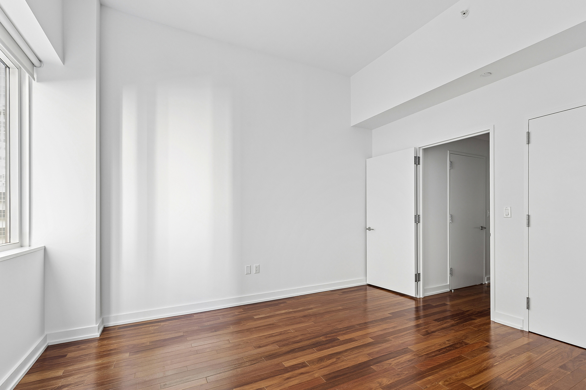 60 East 55th Street, Unit 20A Manhattan, NY 10022 - Photo 8 of 9 a view of an empty room with wooden floor