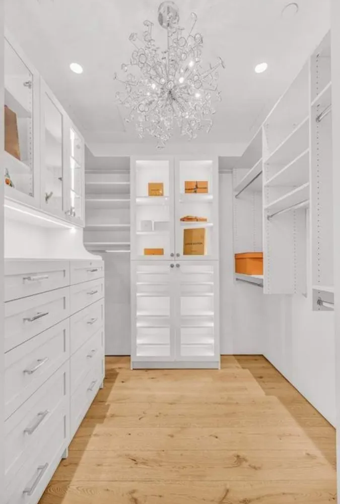 a view of a hallway with closet and chandelier