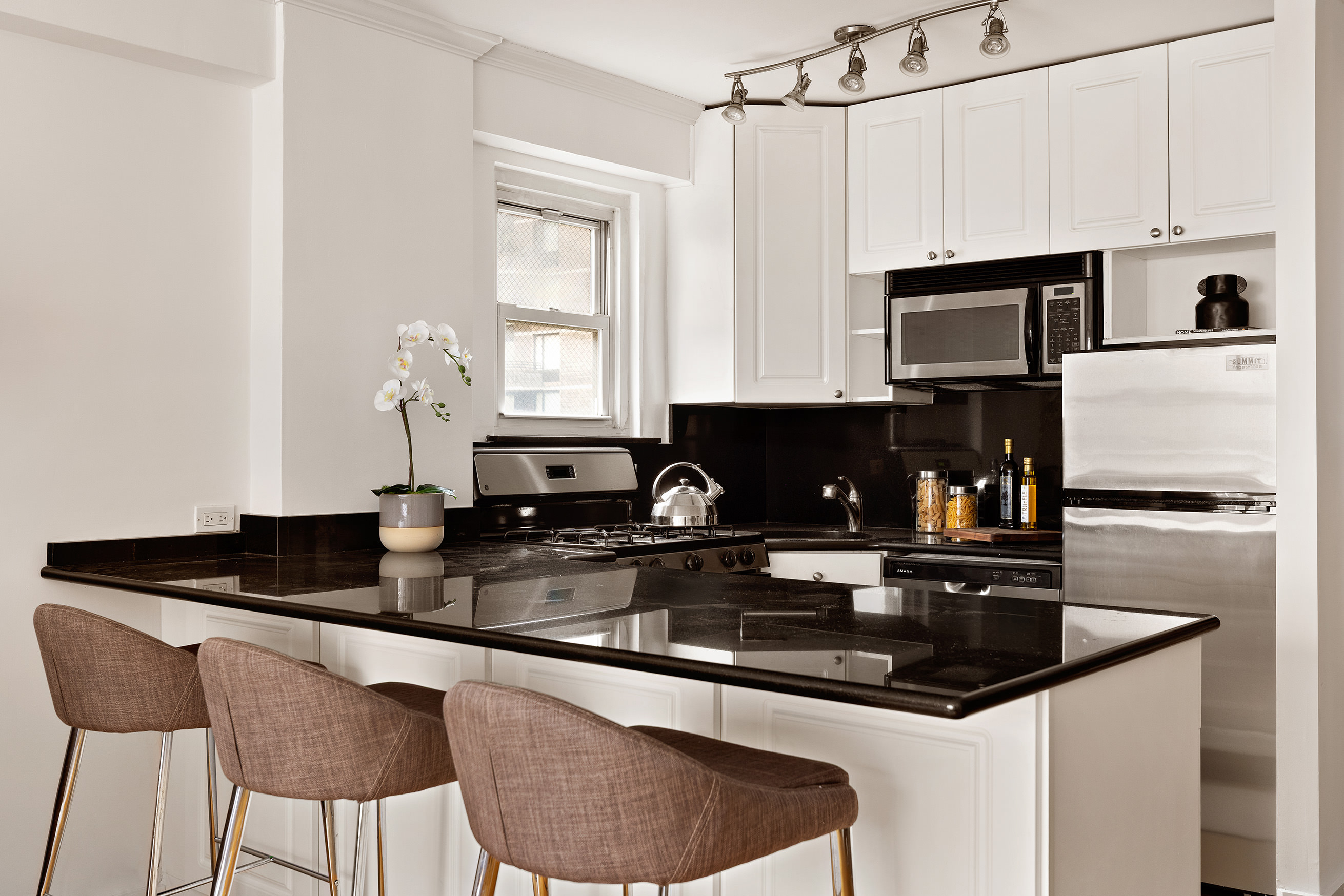 330 East 49th Street, Unit 9C Manhattan, NY 10017 - Photo 4 of 13 a kitchen with granite countertop a sink a stove and refrigerator