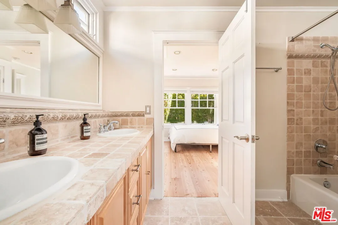 a bathroom with a tub sink and mirror