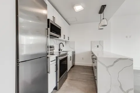 a kitchen with stainless steel appliances granite countertop a refrigerator and a stove top oven