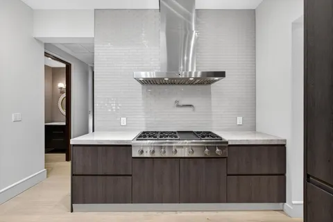 a kitchen with stainless steel appliances granite countertop a sink stove and cabinets