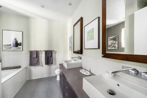 a bathroom with a tub sink and mirror