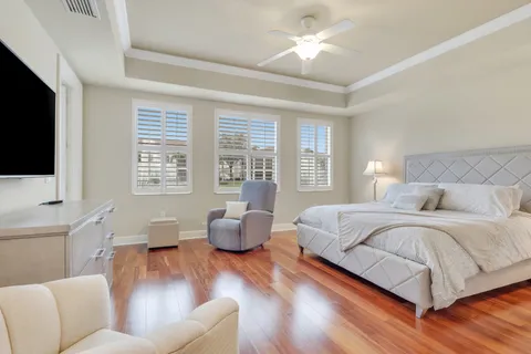 a spacious bedroom with a large bed a flat tv screen and a couch