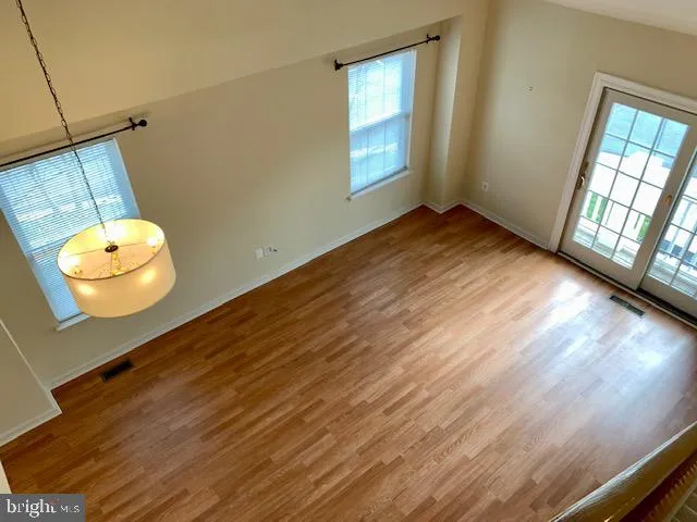 a view of a room with wooden floor and windows