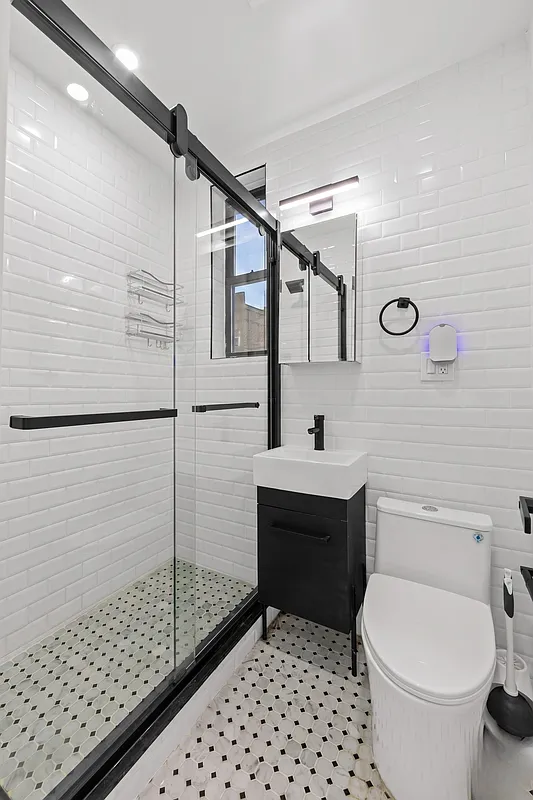 301 East 90th Street, Unit 4C Manhattan, NY 10128 - Photo 7 of 11 a bathroom with a sink a toilet and shower